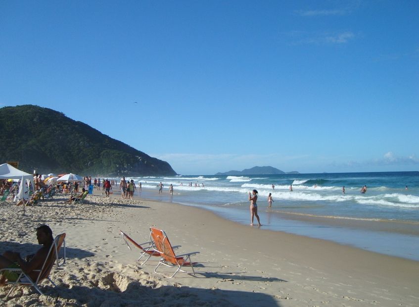 Faixa de areia da Praia Brava com banhistas e ondas